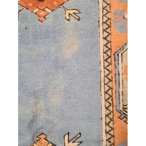 404 - A peach ground Turkish Milas carpet, 20th century, with a central blue rectangle and geometric decor... 