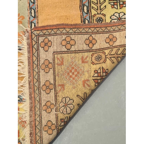 404 - A peach ground Turkish Milas carpet, 20th century, with a central blue rectangle and geometric decor... 