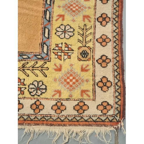 404 - A peach ground Turkish Milas carpet, 20th century, with a central blue rectangle and geometric decor... 