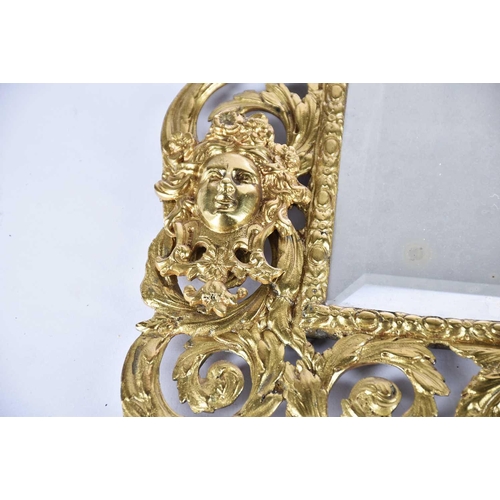 411 - A Victorian cast and gilt brass wall mirror with Vitruvian scroll border and Athene and satyr mask d... 