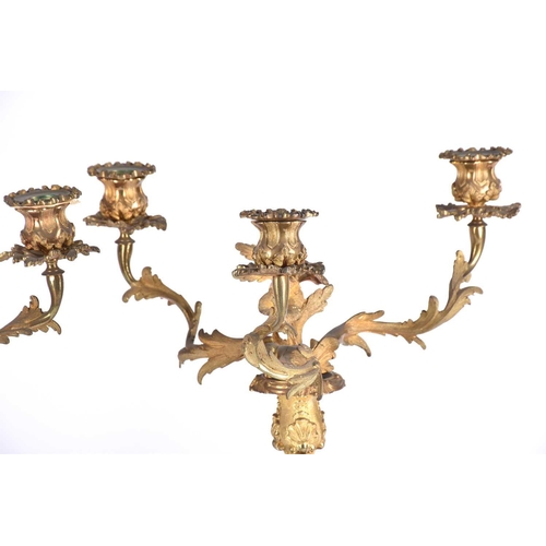 412 - A pair of gilt metal three branch candelabra, late 19th/early 20th century, in the rococo style with... 