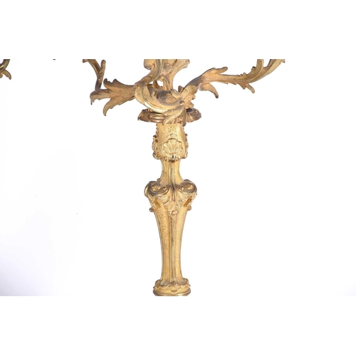 412 - A pair of gilt metal three branch candelabra, late 19th/early 20th century, in the rococo style with... 