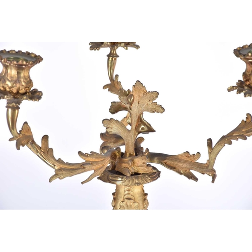 412 - A pair of gilt metal three branch candelabra, late 19th/early 20th century, in the rococo style with... 