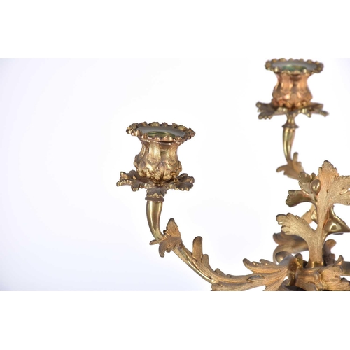 412 - A pair of gilt metal three branch candelabra, late 19th/early 20th century, in the rococo style with... 