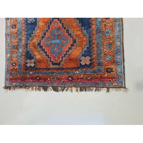 423 - A Caucasian rust ground Lori Pambak rug, 20th century, with three stepped lozenges containing distin... 