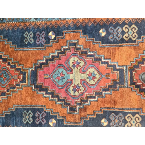 423 - A Caucasian rust ground Lori Pambak rug, 20th century, with three stepped lozenges containing distin... 