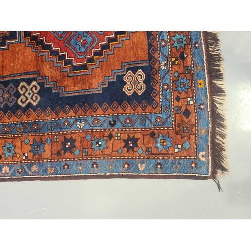 423 - A Caucasian rust ground Lori Pambak rug, 20th century, with three stepped lozenges containing distin... 