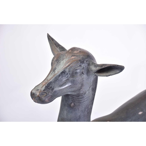 452 - A pair of Art Deco style patinated figures of deer, 20th century, on simple rectangular hollow bases... 