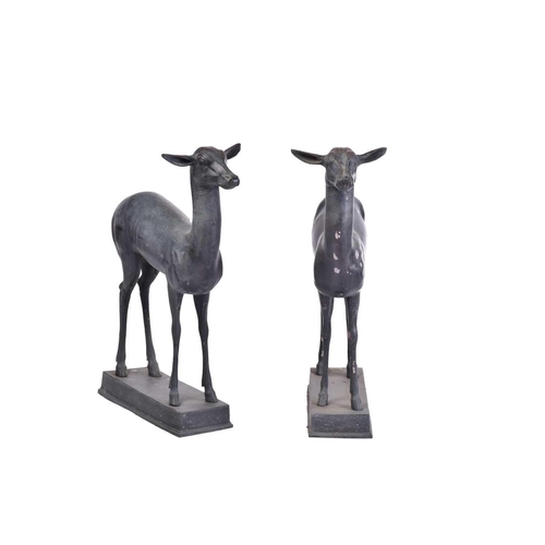 452 - A pair of Art Deco style patinated figures of deer, 20th century, on simple rectangular hollow bases... 