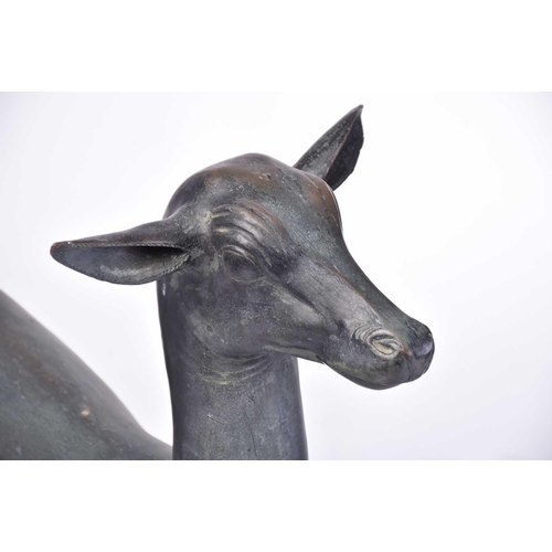 452 - A pair of Art Deco style patinated figures of deer, 20th century, on simple rectangular hollow bases... 