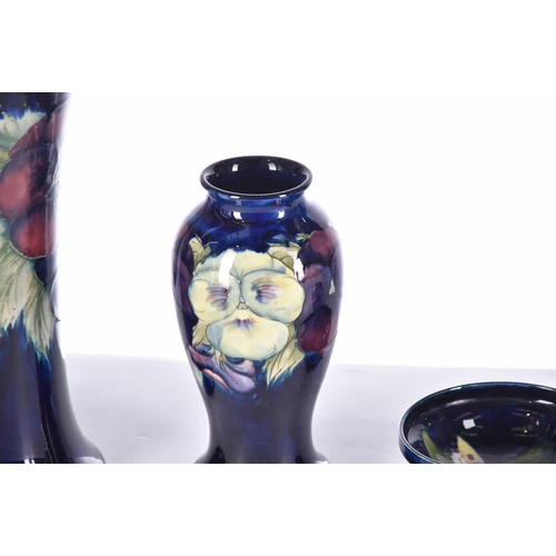 485 - Four items of Moorcroft, comprising a large pansy vase, another smaller pansy vase, a small pedestal... 