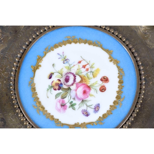 517 - A Sevres style panel set into a gilt metal dish, 19th century, painted with a floral spray on a blue... 