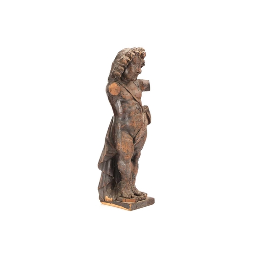 533 - An 18th century Italian carved limewood cherub figure lacking arms, in standing pose and supported o... 