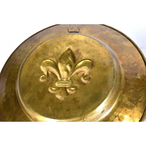 591 - A pair of 19th century Nuremberg style embossed brass alms dishes, the centre with a fleur de lis wi... 