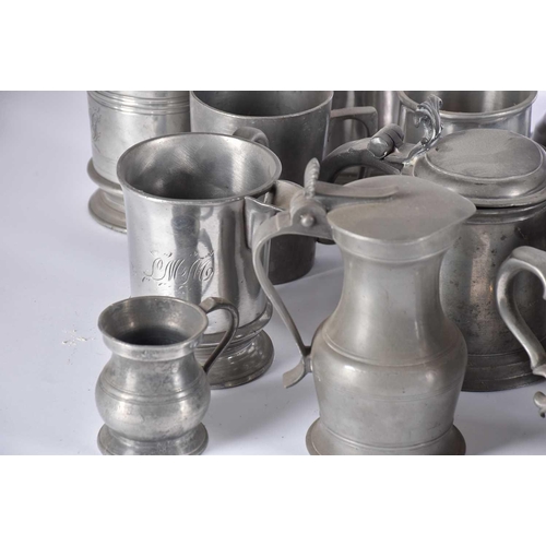 597 - A pair of pewter candlesticks and a large collection of pewter tankards and jugs, principally 19th c... 