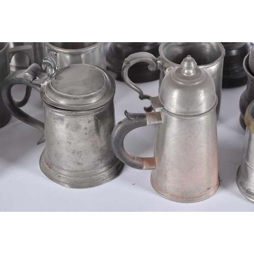 597 - A pair of pewter candlesticks and a large collection of pewter tankards and jugs, principally 19th c... 