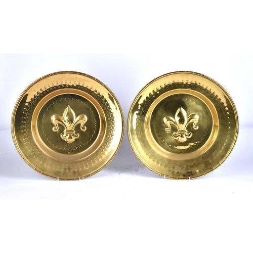 591 - A pair of 19th century Nuremberg style embossed brass alms dishes, the centre with a fleur de lis wi... 