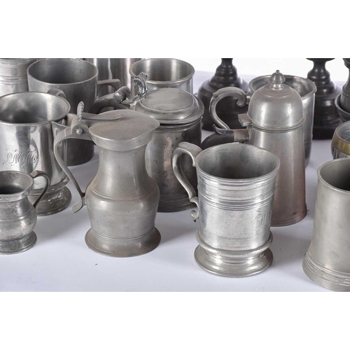 597 - A pair of pewter candlesticks and a large collection of pewter tankards and jugs, principally 19th c... 