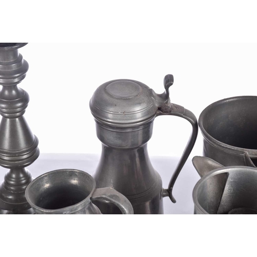 597 - A pair of pewter candlesticks and a large collection of pewter tankards and jugs, principally 19th c... 