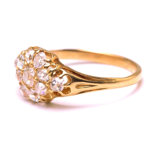 117 - A diamond cluster ring in 18ct gold, consisting of eleven multi-shaped old-cut diamonds, scintillati... 