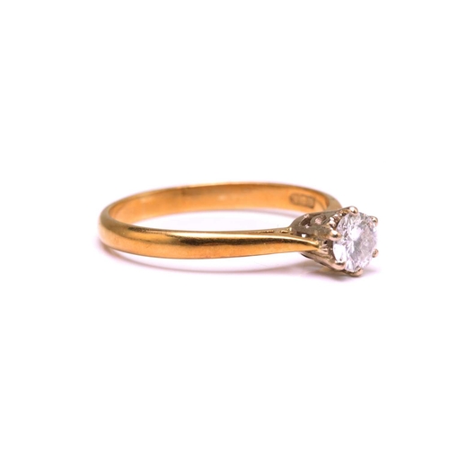 15 - A diamond solitaire ring in 18ct bi-coloured gold, featuring a round brilliant diamond with an estim... 