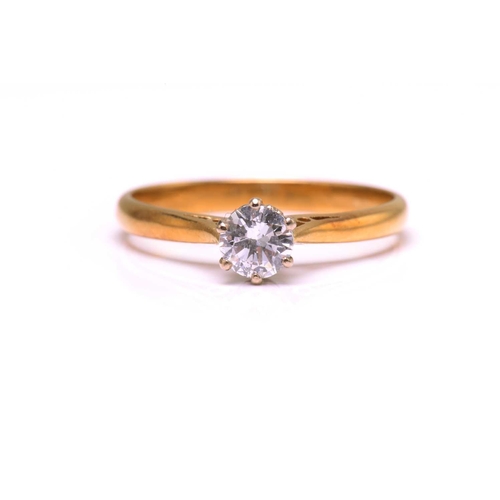15 - A diamond solitaire ring in 18ct bi-coloured gold, featuring a round brilliant diamond with an estim... 