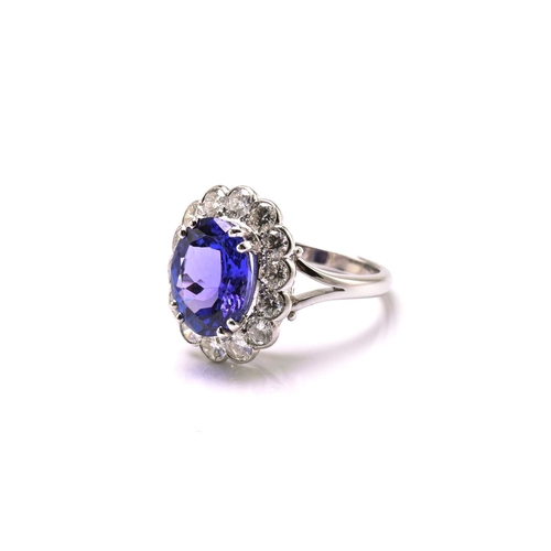 211 - A platinum tanzanite entourage ring, featuring an oval mixed-cut tanzanite with intense purplish-blu... 