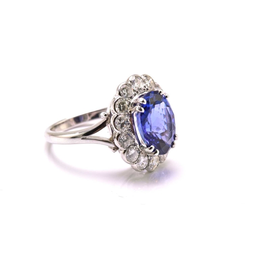 211 - A platinum tanzanite entourage ring, featuring an oval mixed-cut tanzanite with intense purplish-blu... 