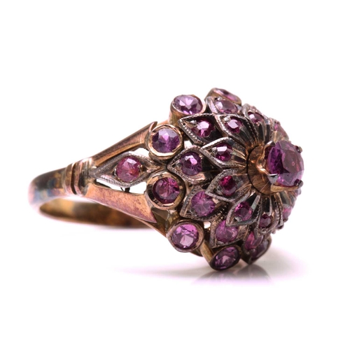 229 - A bombé ring encrusted with pink sapphires, with a screw-top claw mount with a pink sapphire highlig... 
