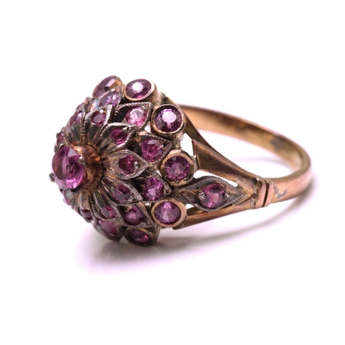 229 - A bombé ring encrusted with pink sapphires, with a screw-top claw mount with a pink sapphire highlig... 