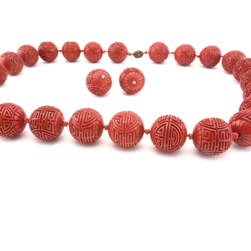 3 - A Chinese lacquer carved bead necklace and matching earrings; the necklace consists of twenty-five s... 