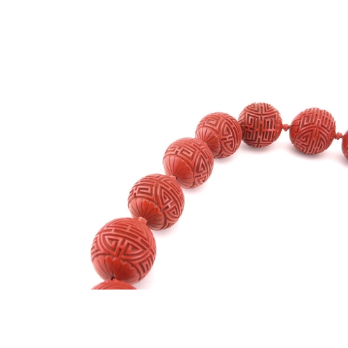 3 - A Chinese lacquer carved bead necklace and matching earrings; the necklace consists of twenty-five s... 