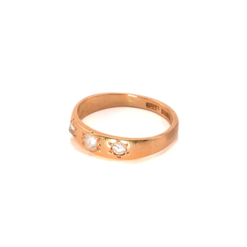 57 - A three-stone diamond ring; the slightly graduated, mixed old-cut diamonds star set within a taperin... 