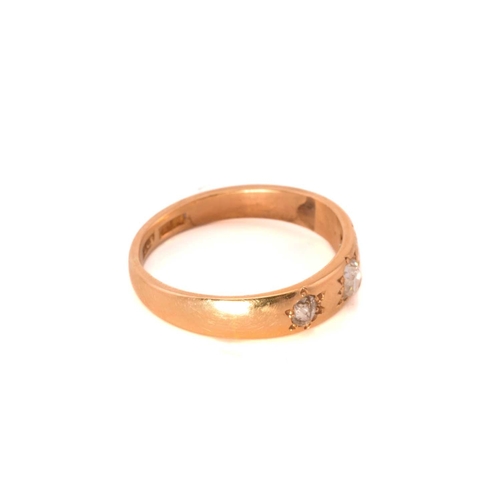 57 - A three-stone diamond ring; the slightly graduated, mixed old-cut diamonds star set within a taperin... 