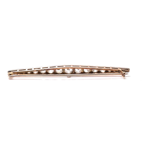 6 - A Victorian diamond bar brooch navette shaped and set with twenty one old brilliant cut diamonds gra... 