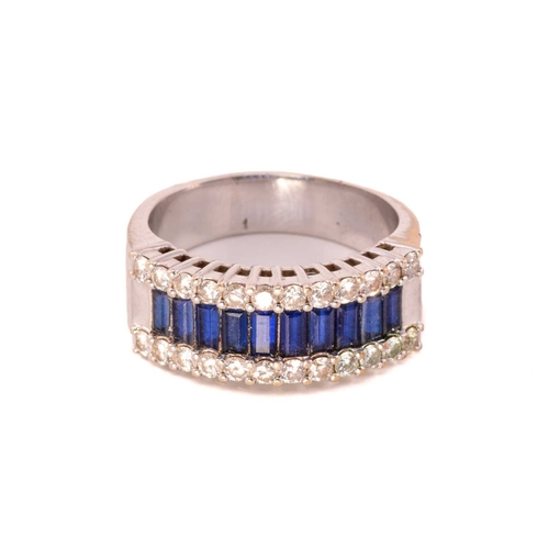 61 - A three-row sapphire and diamond dress ring, set with a central tramline of baguette-cut synthetic s... 