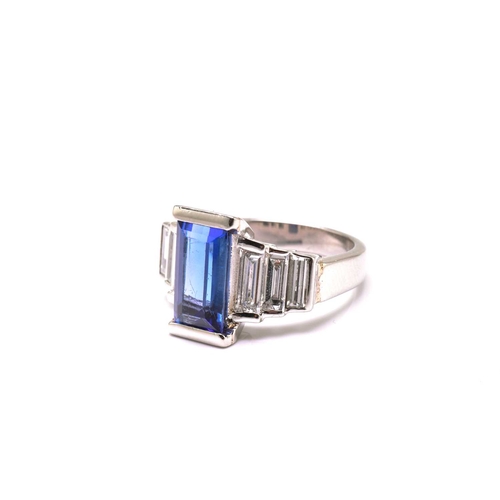 75 - An Art Deco-style platinum tanzanite and diamond ring, featuring a tapered rectangular step-cut tanz... 