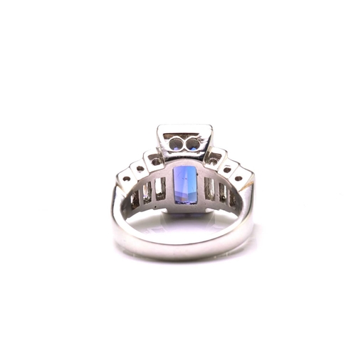 75 - An Art Deco-style platinum tanzanite and diamond ring, featuring a tapered rectangular step-cut tanz... 