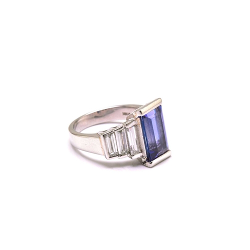 75 - An Art Deco-style platinum tanzanite and diamond ring, featuring a tapered rectangular step-cut tanz... 