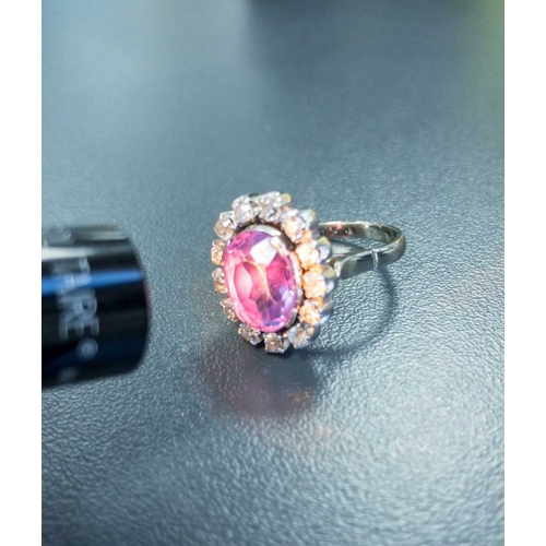 83 - A synthetic colour-changing sapphire and diamond cluster ring, centred with an oval cut synthetic co... 