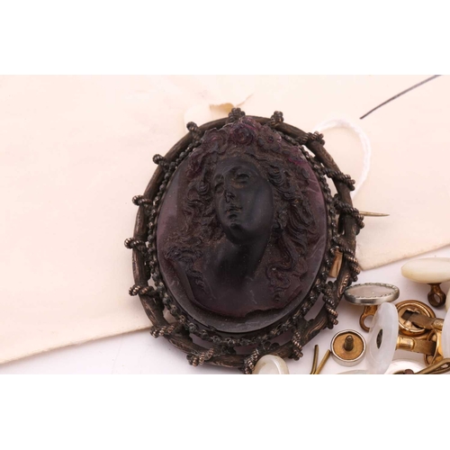 85 - A moulded glass cameo style brooch; the purple frosted glass bust portrait of a woman with ringlets ... 