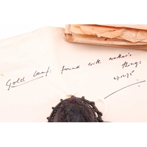 85 - A moulded glass cameo style brooch; the purple frosted glass bust portrait of a woman with ringlets ... 