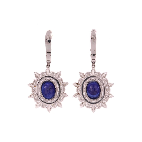 92 - A pair of sapphire and diamond drop earrings, each comprising an oval faceted sapphire with dark blu... 