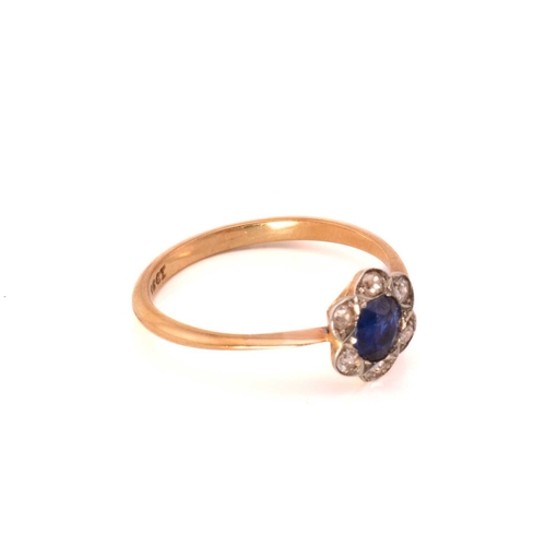 243 - A sapphire and diamond flower head ring, featuring a round sapphire claw set in the centre and surro... 