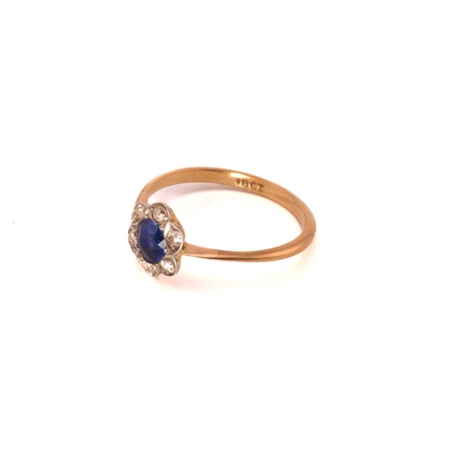 243 - A sapphire and diamond flower head ring, featuring a round sapphire claw set in the centre and surro... 