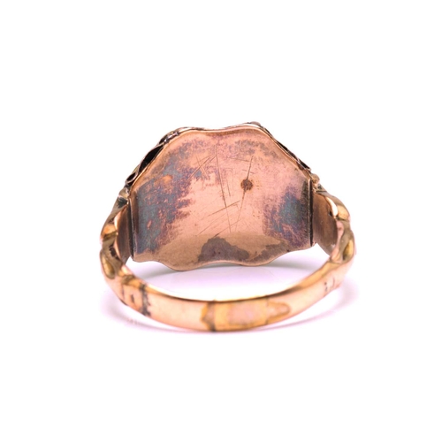247 - A gem-set dress ring in yellow metal, featuring an oval cut garnet in the centre flanked by two foil... 