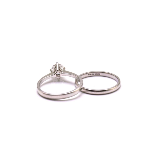251 - A platinum diamond solitaire ring and platinum wedding band, the solitaire ring comprises a round br... 