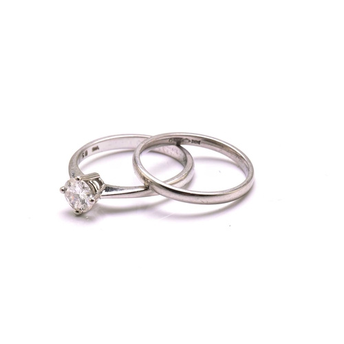 251 - A platinum diamond solitaire ring and platinum wedding band, the solitaire ring comprises a round br... 