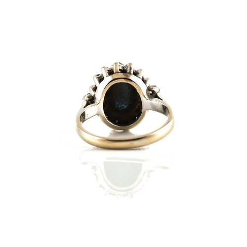 265 - A sapphire and diamond halo ring, featuring an oval sapphire high dome cabochon in dark blue colour,... 