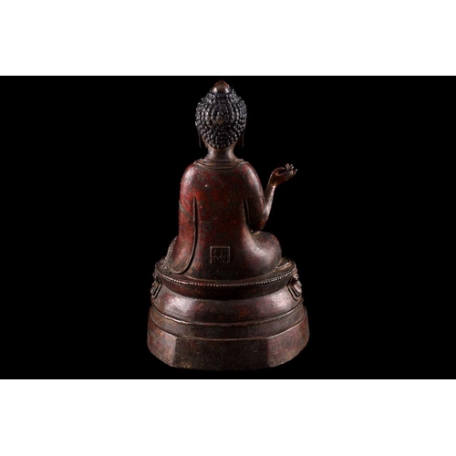 101 - A Chinese bronze figure of Buddha, seated in Abhaya mudra, the hair in tight curls, seated on a lotu... 